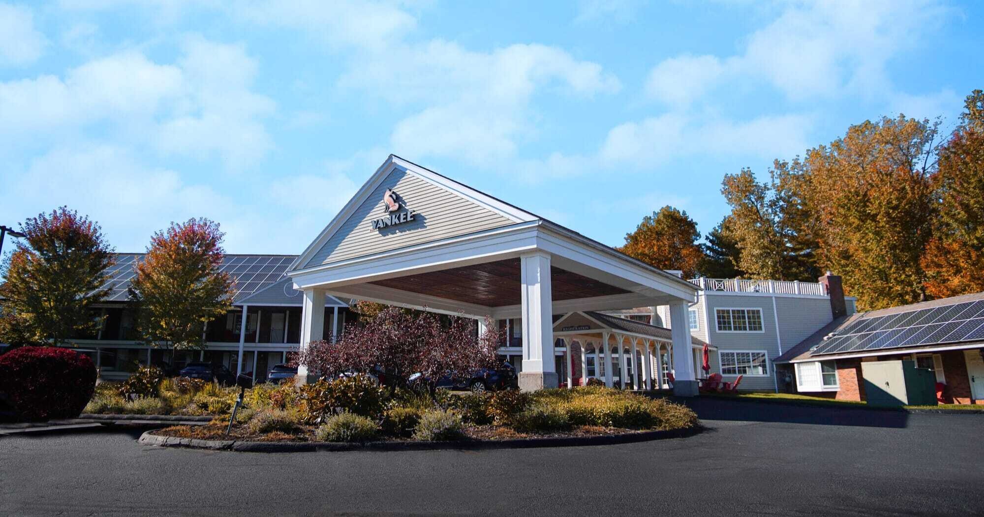 The Yankee Inn front entrance with covered portico and autumn Berkshires landscaping in Lenox, MA