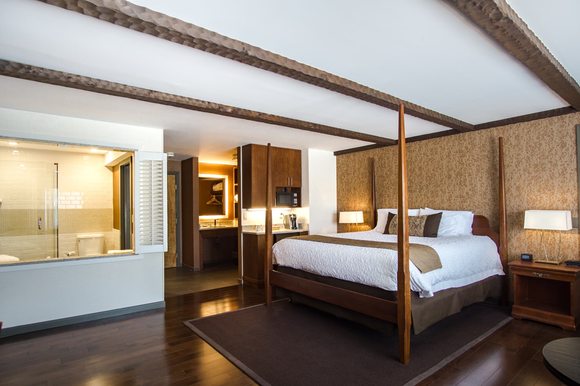 King Premier room at The Yankee Inn with four-poster bed, exposed wood beams, and ensuite bathroom