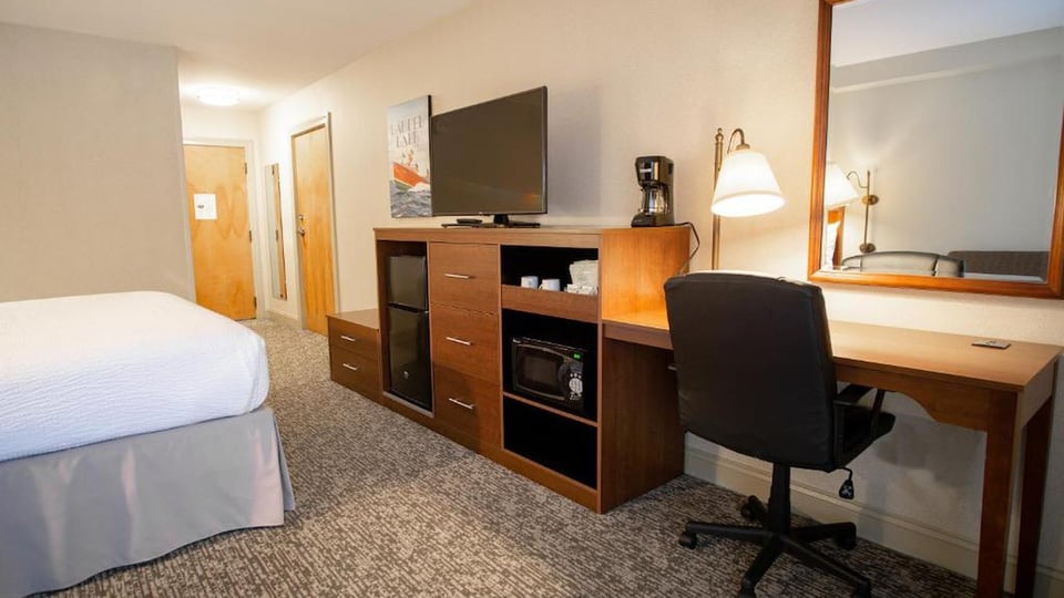 In-room work desk with mini-fridge, microwave, coffee maker, and flat-screen TV in the King Mountain View room