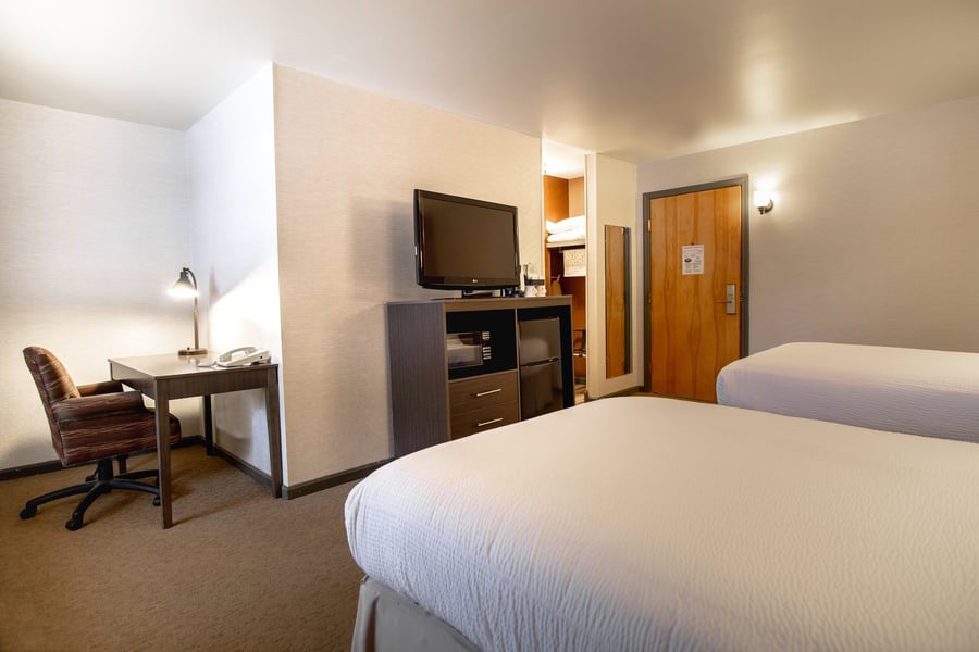 Spacious Two Doubles Deluxe room with work desk, ergonomic chair, mini-fridge, and microwave amenity center