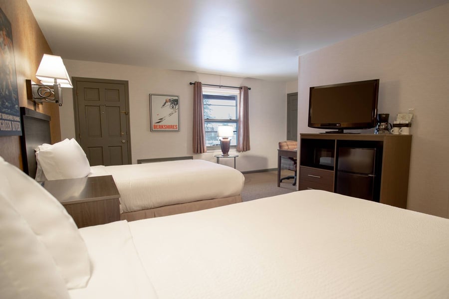 Two Doubles Deluxe room featuring flat-screen TV, work desk area, and natural light from a curtained window