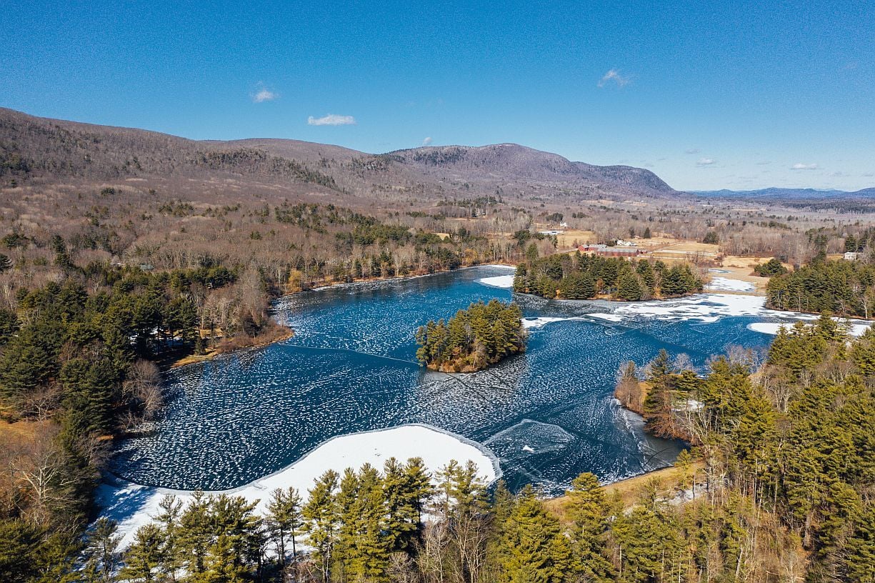 Aerial view of the partially frozen pond and Berkshire hills near The Yankee Inn in winter