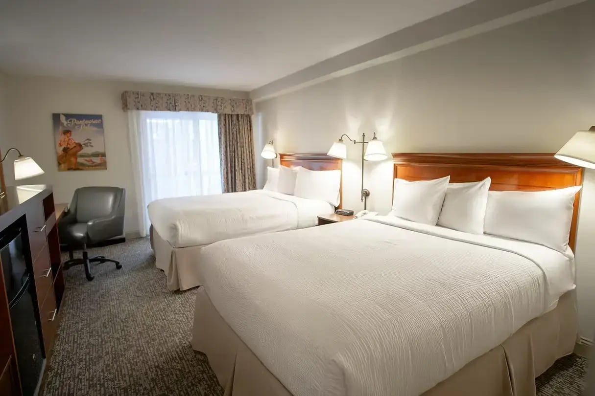 Deluxe room with two queen beds, balcony access, and Berkshires-inspired decor at The Yankee Inn in Lenox