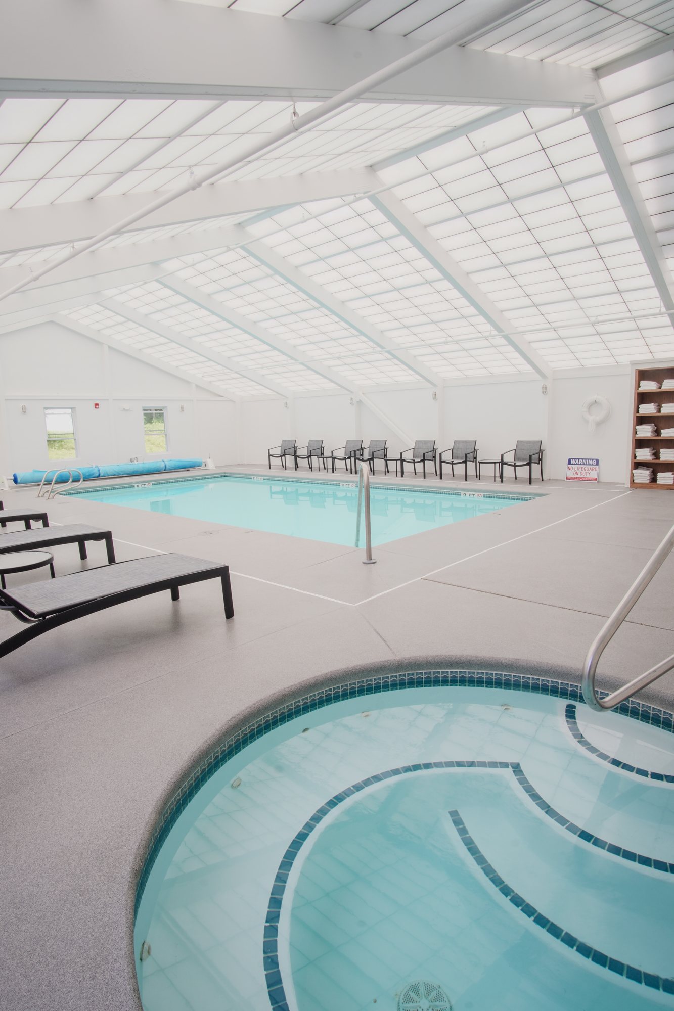Heated indoor pool with lounge chairs and vaulted ceiling at The Yankee Inn