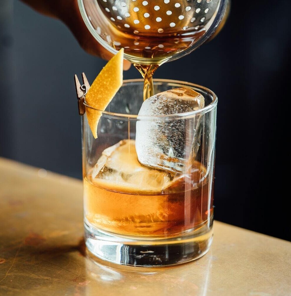 Handcrafted cocktail being poured over ice at the on-site Foxtrail Lounge bar