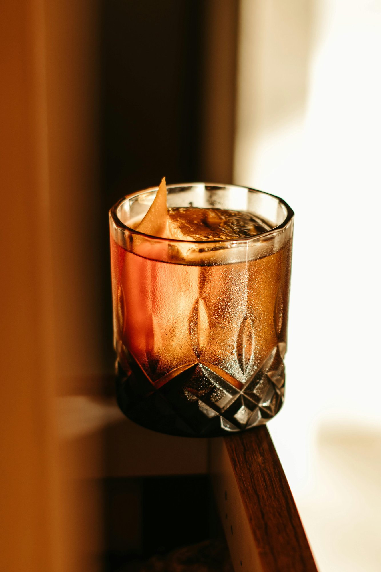 Whiskey cocktail glass on a sunlit windowsill at Foxtrail Lounge