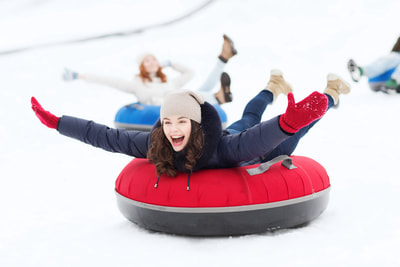 A girl riding a snow tube down a hill